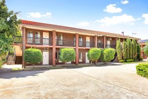 un edificio de apartamentos con árboles delante de él en Comfort Inn & Suites Sombrero en Adelaida