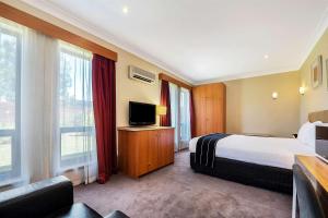 a hotel room with a bed and a television at Comfort Inn & Suites Sombrero in Adelaide