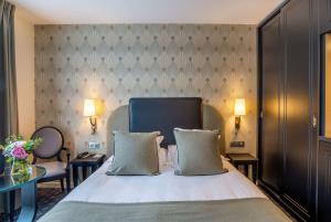 a hotel room with a bed and a table at Best Western Plus Le Moderne in Caen