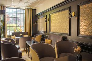 a waiting room at a restaurant with chairs and tables at Best Western Plus Le Moderne in Caen