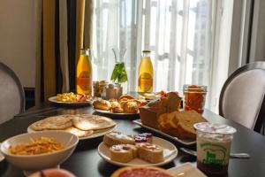 a table topped with plates of food and drinks at Best Western Plus Le Moderne in Caen