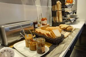a counter with bread and a basket of bread at Best Western Plus Le Moderne in Caen