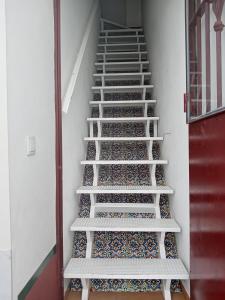 uma escada num quarto com azulejos nas escadas em Apartamento El Colmao em Chipiona