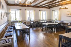 Jugendherberge Husum في هوسوم: غرفة طعام مع طاولات وكراسي ونوافذ