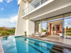 a villa with a swimming pool and a house at Premier Residences Phu Quoc Emerald Bay Managed by Accor in Phú Quốc