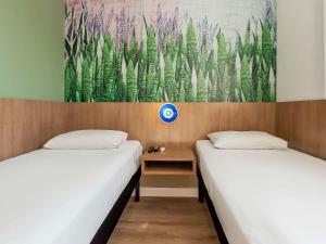 2 camas en una habitación con un cuadro en la pared en ibis Styles Araraquara, en Araraquara