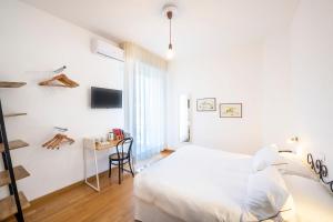 a white bedroom with a bed and a desk at Hotel San Michele in Celle Ligure