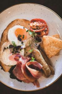 un piatto di prodotti per la colazione con uova, pancetta e pane tostato di Rendezvous Hotel Melbourne a Melbourne