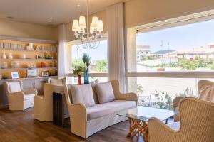a living room with a couch and chairs and a large window at Best Western Hotel Matisse in Sainte-Maxime