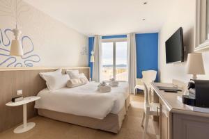a hotel room with a bed and a desk and a kitchen at Best Western Hotel Matisse in Sainte-Maxime
