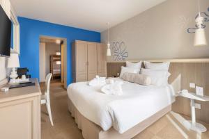 a bedroom with a large white bed with towels on it at Best Western Hotel Matisse in Sainte-Maxime