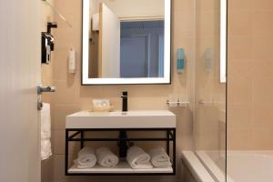 a bathroom with a sink and a mirror and a shower at Best Western Hotel Matisse in Sainte-Maxime