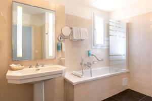 a bathroom with a sink and a shower and a mirror at Best Western Hotel Matisse in Sainte-Maxime
