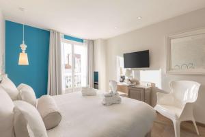 a bedroom with a white bed with white chairs and a tv at Best Western Hotel Matisse in Sainte-Maxime