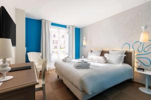 Schlafzimmer mit einem Bett mit blauen Wänden und einem Schreibtisch in der Unterkunft Best Western Hotel Matisse in Sainte-Maxime