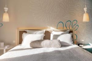 a bedroom with a large bed with white pillows at Best Western Hotel Matisse in Sainte-Maxime