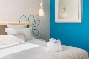 a bedroom with a bed with a towel on it at Best Western Hotel Matisse in Sainte-Maxime