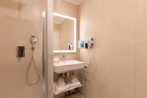 a bathroom with a sink and a shower with a mirror at Best Western Hotel Matisse in Sainte-Maxime