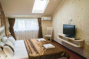 a hotel room with a bed and a television at Sapsan in Ternopilʼ