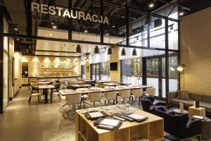 restauracja ze stołami i krzesłami w pokoju w obiekcie CAMPANILE PRIME Warszawa Centrum w Warszawie