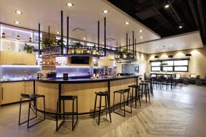 bar z stołkami w dużym pokoju w obiekcie CAMPANILE PRIME Warszawa Centrum w Warszawie