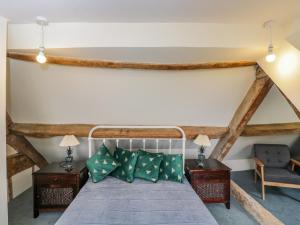 a bedroom with a bed and two tables and a chair at 9 Velley Hill in Corsham