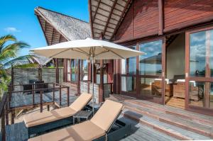 a patio with chairs and an umbrella on a house at Massinga Beach in Massinga