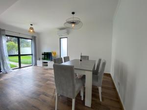 a dining room with a white table and chairs at Casa da Estrela in Ribeira Grande