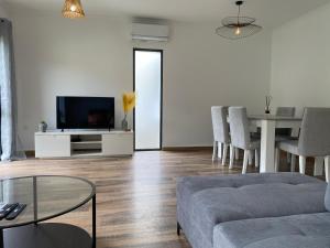 a living room with a couch and a tv and a table at Casa da Estrela in Ribeira Grande