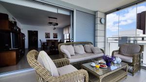 salon z wiklinowymi krzesłami i kanapą w obiekcie BAUPRES luxury apartment w mieście Calpe