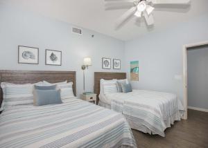 een slaapkamer met 2 bedden en een plafondventilator bij Phoenix V 1404 in Orange Beach
