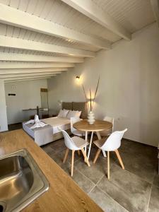 a kitchen with a table and chairs and a bed at Issos Residence in Agios Georgios