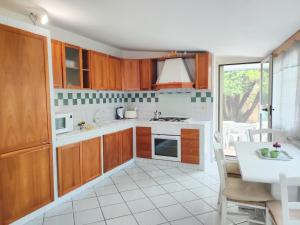 Il comprend une cuisine avec des placards en bois et du carrelage blanc. dans l'établissement Villa Dolce Cuma, à Pouzzoles