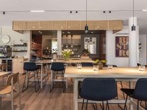 a large kitchen with a large island with bar stools at Oru Hub Hotel Tallinn - Handwritten Collection in Tallinn