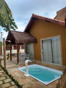 a swimming pool in front of a house at Maragogi Chalés Antunes in Maragogi