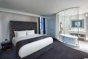 - une chambre d'hôtel avec un lit et une baignoire dans l'établissement Dream Midtown, by Hyatt, à New York