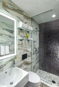 een badkamer met een wastafel, een toilet en een douche bij Dream Midtown, by Hyatt in New York