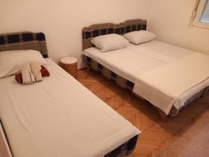 two twin beds in a room with wooden floors at Luxury Apartment in Ulcinj