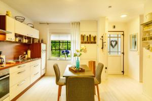 a kitchen with a table and chairs and a dining room at Huus ant Dörpsdiek in Krummhörn