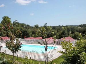vistas a una piscina con árboles en el fondo en Coquadou, en Verneuil-sur-Vienne