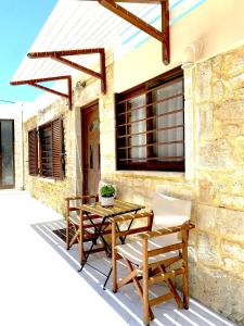 a patio with a table and chairs and a building at Lithos House and Studios in Kissamos