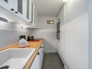 - une cuisine avec des placards blancs et un évier dans l'établissement Studio Méribel, 1 pièce, 4 personnes - FR-1-565-60, à Les Allues