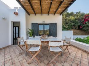 un patio con mesa y sillas en Maison Raffaello - Exclusive villa with sea view, en Geremèas