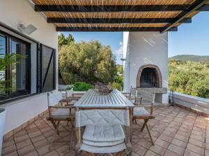 un patio con mesa, sillas y chimenea en Maison Raffaello - Exclusive villa with sea view, en Geremèas