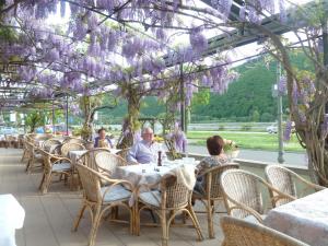 un gruppo di persone sedute a un tavolo con fiori viola di Hotel Schön am Rhein a Rüdesheim am Rhein