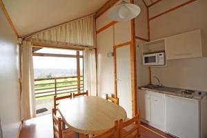 eine Küche und ein Esszimmer mit einem Tisch und einem Fenster in der Unterkunft Echo in Verneuil-sur-Vienne