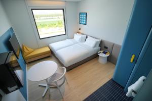 Habitación pequeña con cama, mesa y ventana en GO! Hotel Si Racha at Central Si Racha, en Si Racha