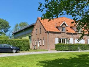 a brick house with a car parked in front of it at Eichenhof (Westhof) in Grothusenkoog