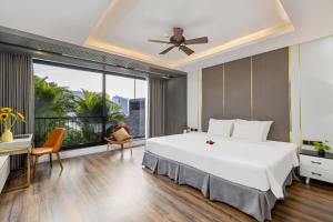峴港的住宿－Chi House Danang Hotel and Apartment，卧室设有一张白色大床和大窗户