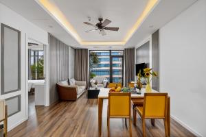 sala de estar con mesa de comedor y sillas amarillas en Chi House Danang Hotel and Apartment en Da Nang